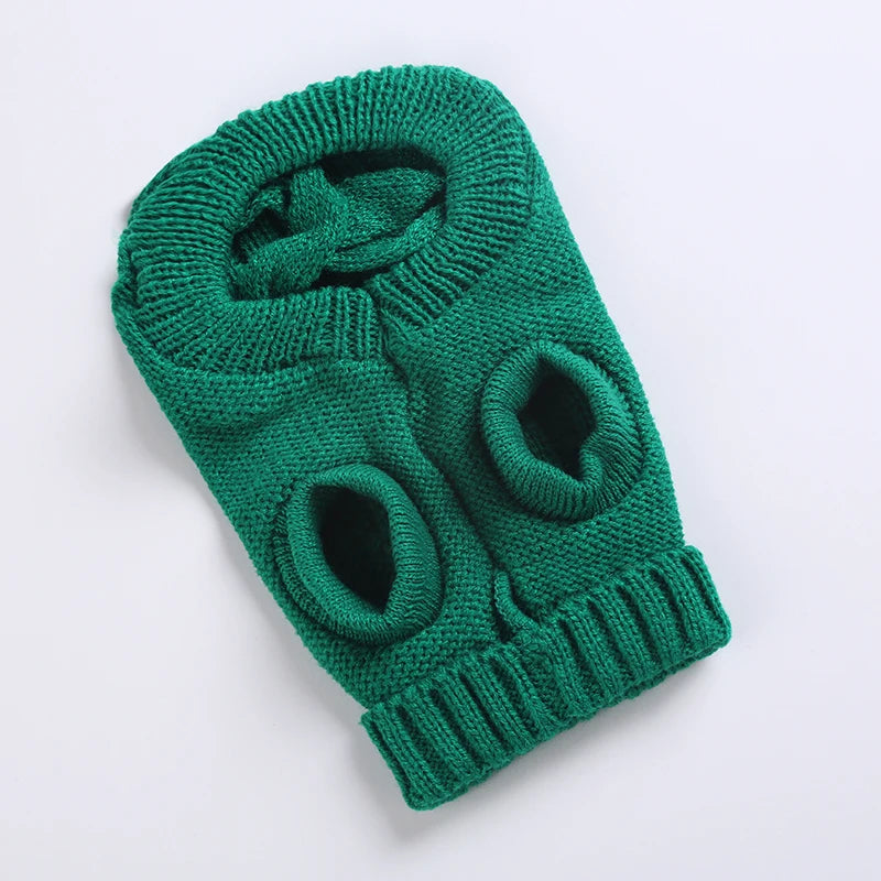 Underside of a green cable knit dog sweater showing the leg openings