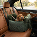 Dachshund in an olive green padded bed on a rear car seat