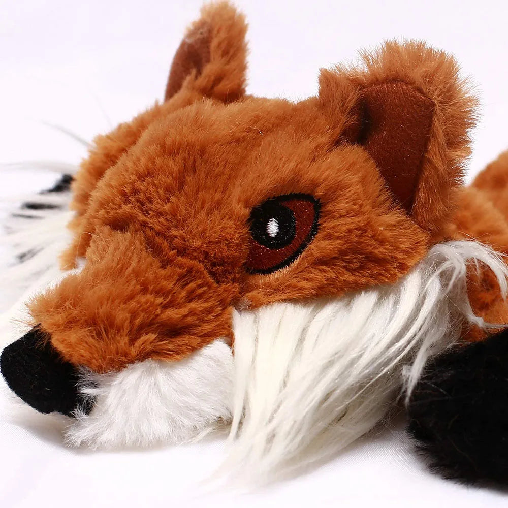 Close-up of an orange fox plush dog toy with a white muzzle
