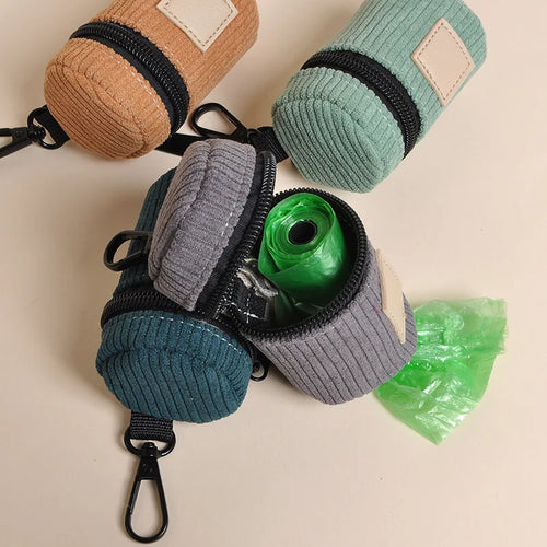 Open gray corduroy walk bag holding accessories beside green and tan bags