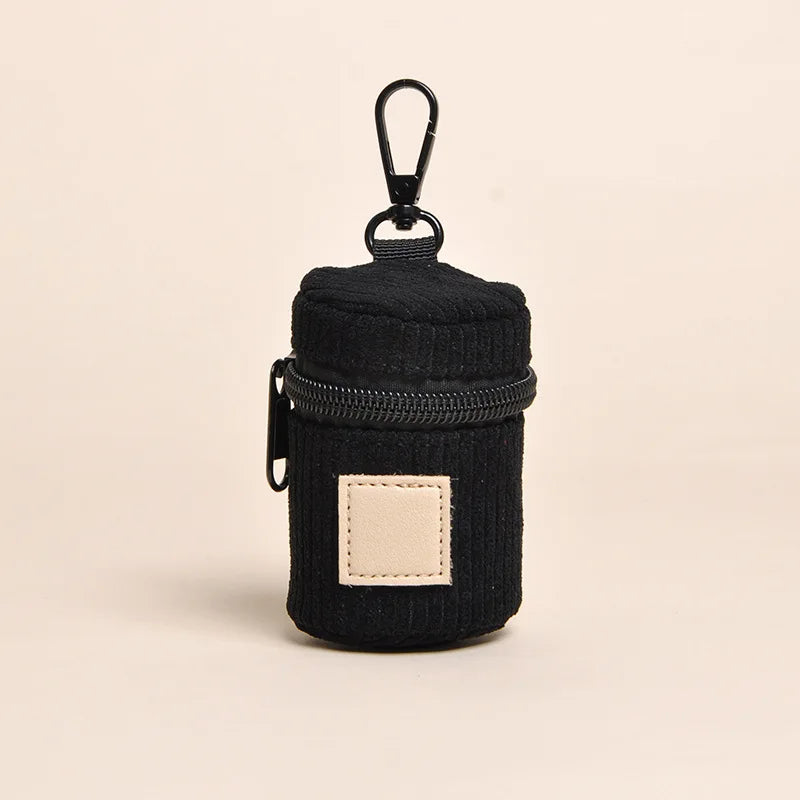 Black corduroy dog poop bag holder with a black zipper and clip
