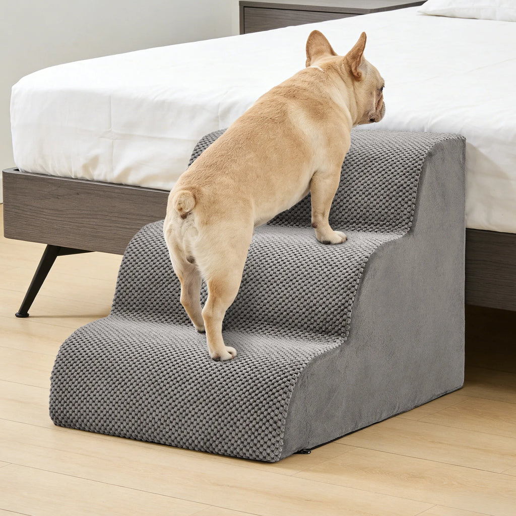 French bulldog using gray foam dog steps to reach a bed